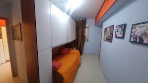 A room with a bed, wardrobe, and wall art. - Apartment 'Casa in Complesso Sonia' with Private Terrace (Santa Teresa di Riva)