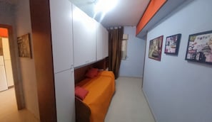 Een kamer met een bed, een kledingkast en wanddecoratie.