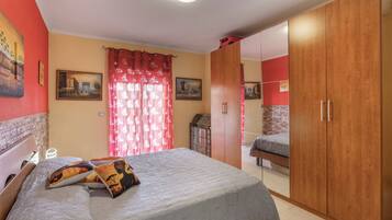 Una stanza con un letto, un armadio e un quadro appeso al muro.