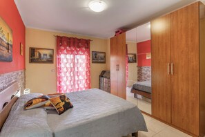 Una habitació amb un llit, un armari i un quadre al mur.