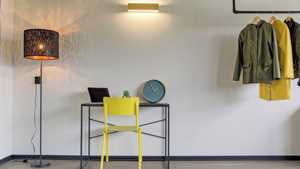 A room with a desk, chair, lamp, clock, and clothes hanging on a rack. - Large Room in Rijswijk (Rijswijk)