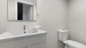 A modern bathroom with a white sink, mirror, and toilet. - Holiday Home 'Lisboa Guest House' with Wi-Fi (Lisboa)