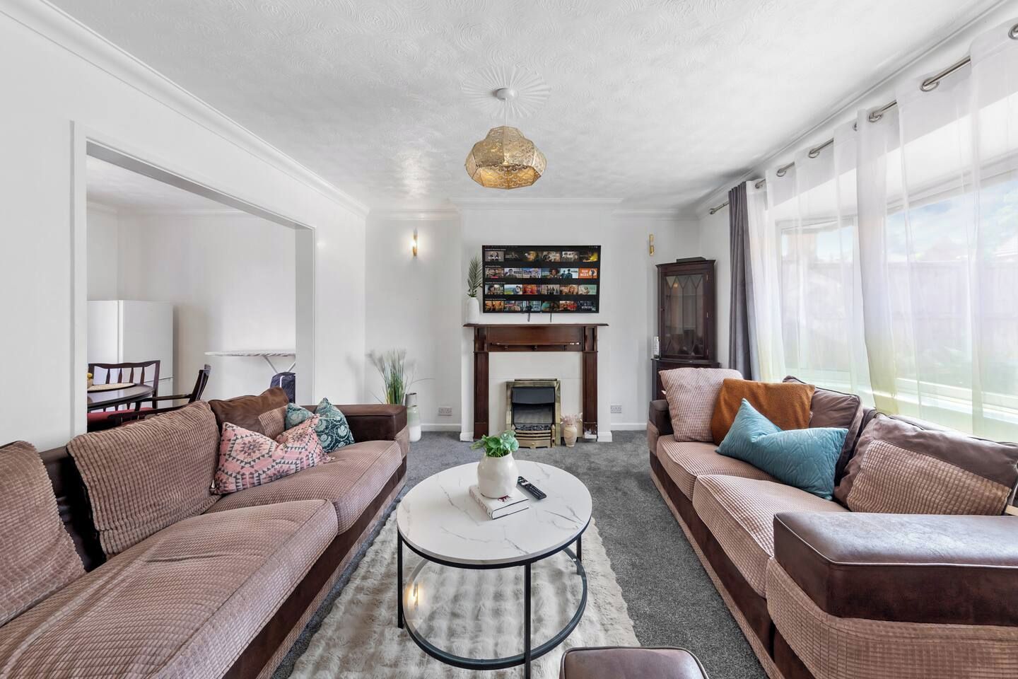 A living room with two sofas, a coffee table, a fireplace, and a bookshelf.