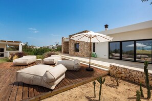 A rooftop patio with outdoor seating and a stone wall. - Villa Marevento by Perle di Puglia (Carovigno)