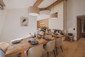 A dining area with a wooden table set for four, surrounded by chairs. - Paradisa Summit - Luxurious penthouse apartment with Mont-Blanc views (Chamonix-Mont-Blanc)