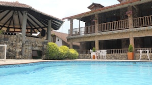 A swimming pool with a stone facade building in the background. - La Casa del Arbol (San Francisco)