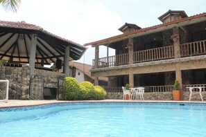 A swimming pool with a stone facade building in the background. - La Casa del Arbol (San Francisco)
