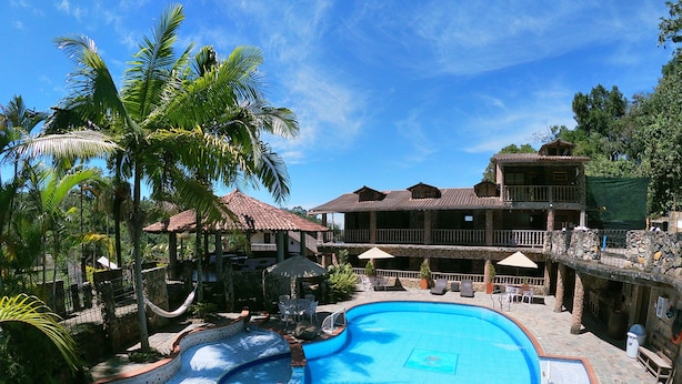 A resort with a swimming pool, outdoor seating, and a multi-story building. - La Casa del Arbol (San Francisco)