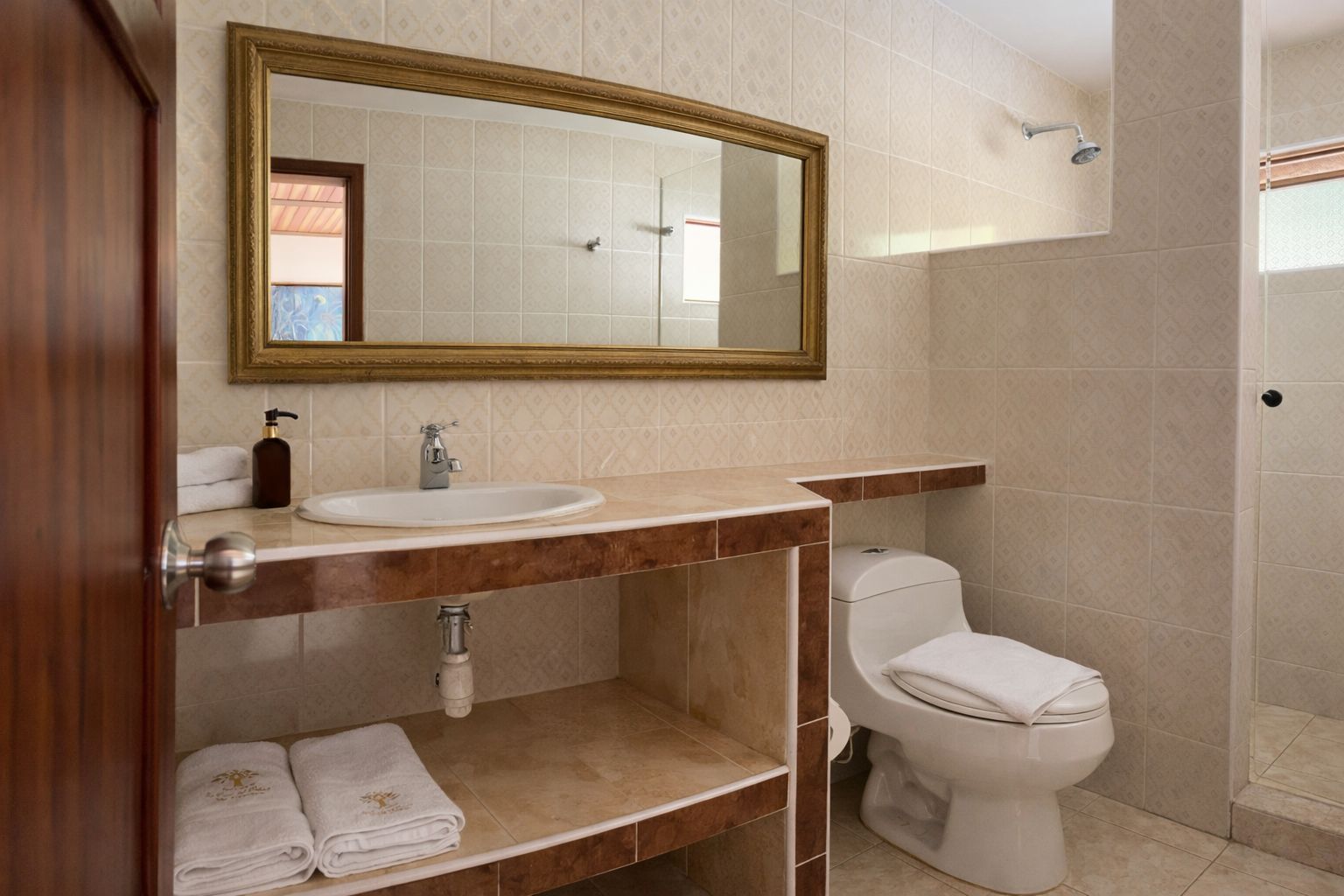 A bathroom with a sink, toilet, and shower.