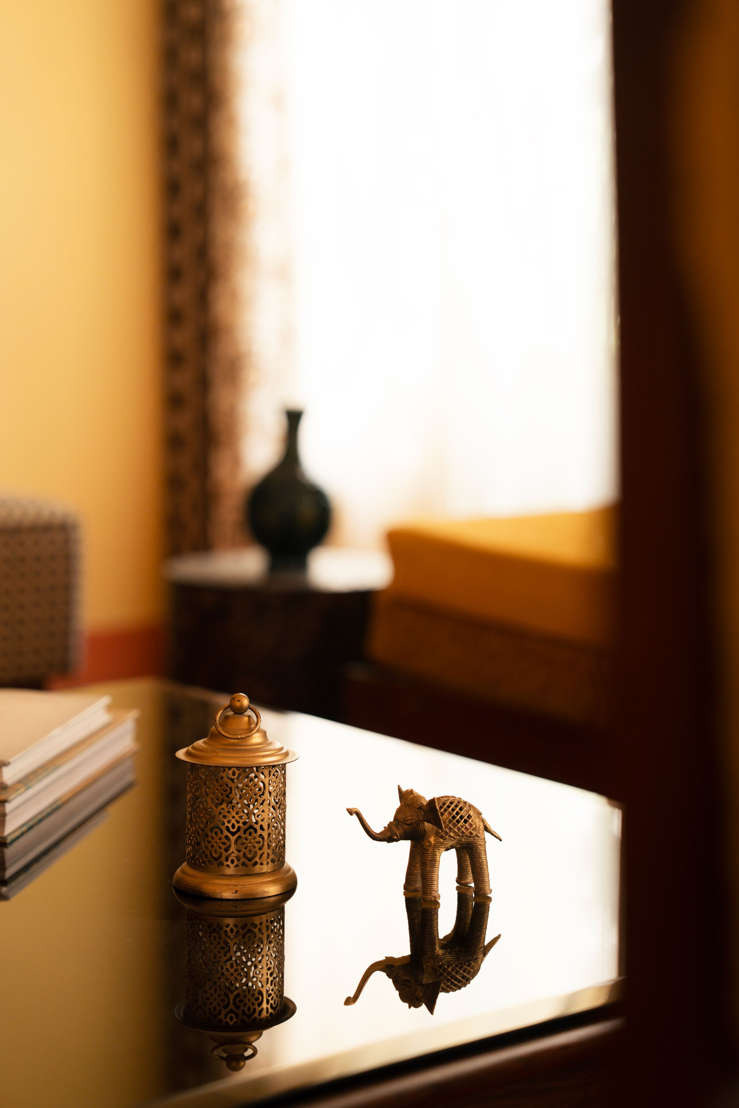 A table with a decorative metal lamp and a small figurine.