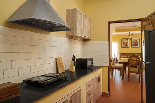 A kitchen with a black countertop, a microwave, a gas stove, and a wooden cabinet.