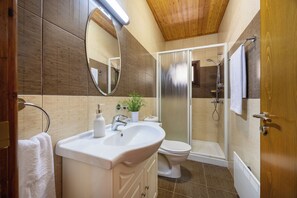 Ein modernes Badezimmer mit Waschbecken, Toilette und einer Duschkabine.