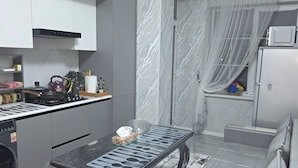 Een kleine keuken met een eethoek, een inbouwoven en een magnetron.