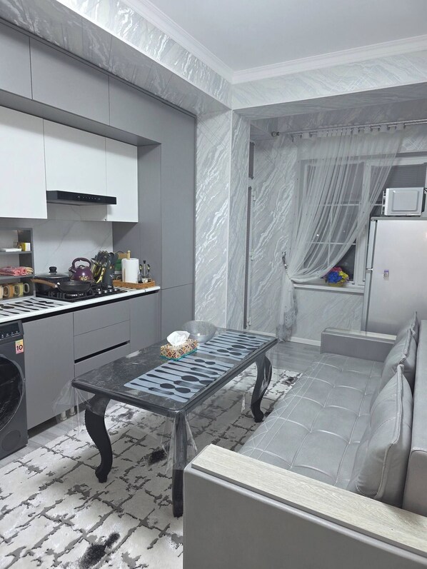 A compact kitchen with a dining area, a built-in oven, and a microwave.