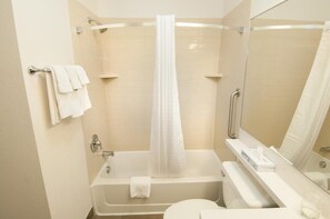 Ein modernes Badezimmer mit Badewanne, Dusche, Toilette und Spiegel.