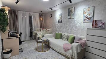 Un salon moderne comprenant un canapé, une table basse et un coin repas avec une table et des chaises.