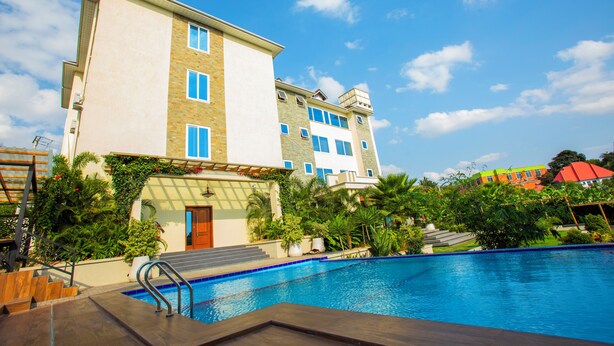 Ein Hotel mit Schwimmbad, mehreren Etagen und einem Garten.