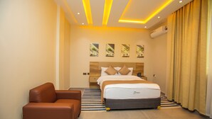 Ein Hotelzimmer mit einem Bett, einer Couch und einer Wand-Klimaanlage.