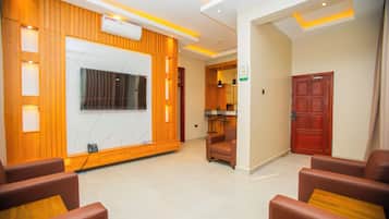 A hotel lobby with a reception desk, seating area, and a closed door.