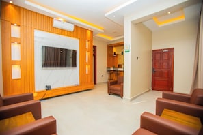 A hotel lobby with a reception desk, seating area, and a closed door.