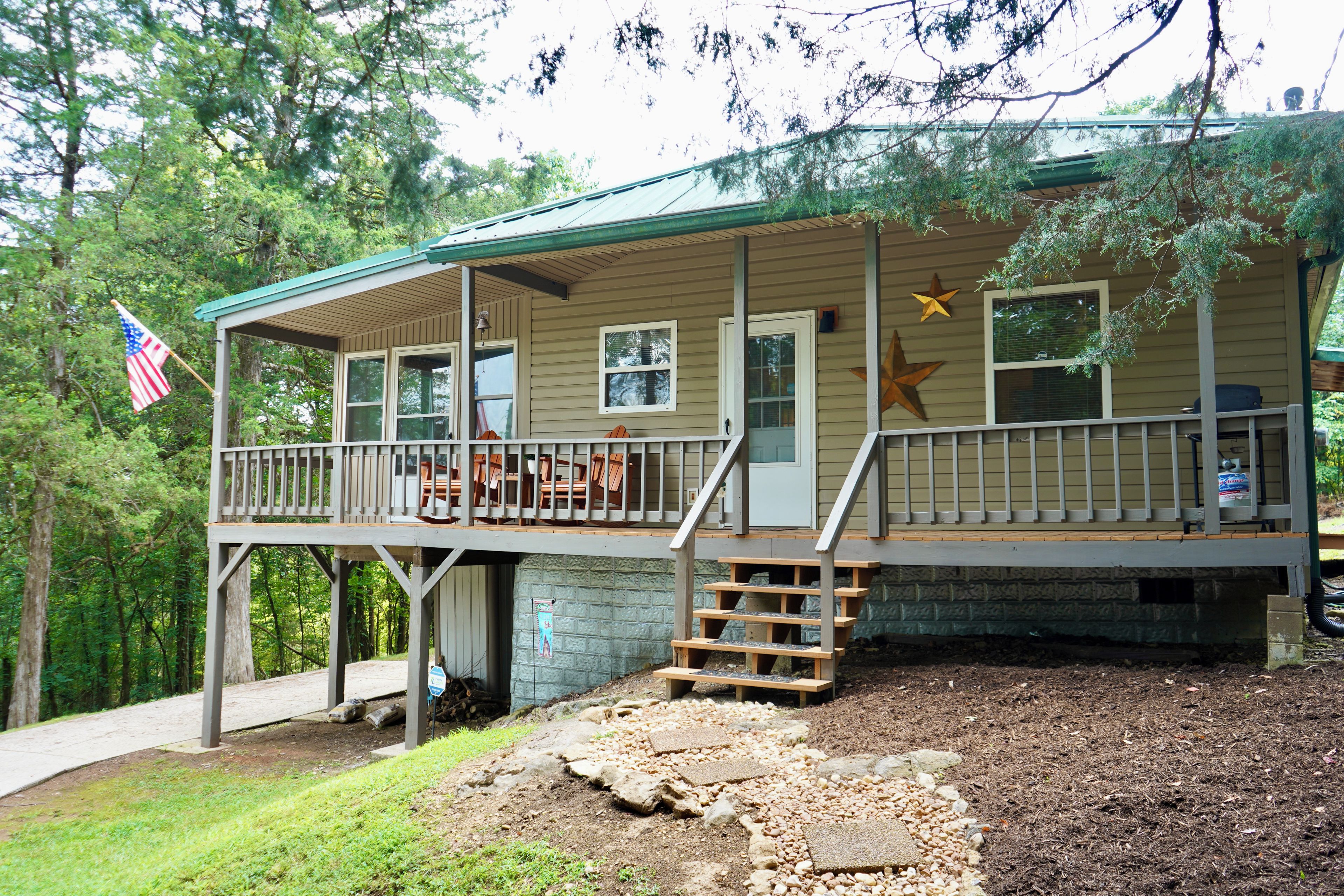 A two-story cabin with a porch, a flag, and a star decoration.
