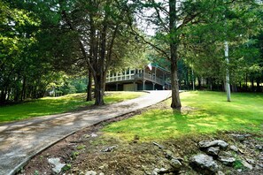 A pathway leading to a building with a balcony, surrounded by trees and grass. - Cozy 2-bedroom house near Cordell Hull Lake (Gainesboro)