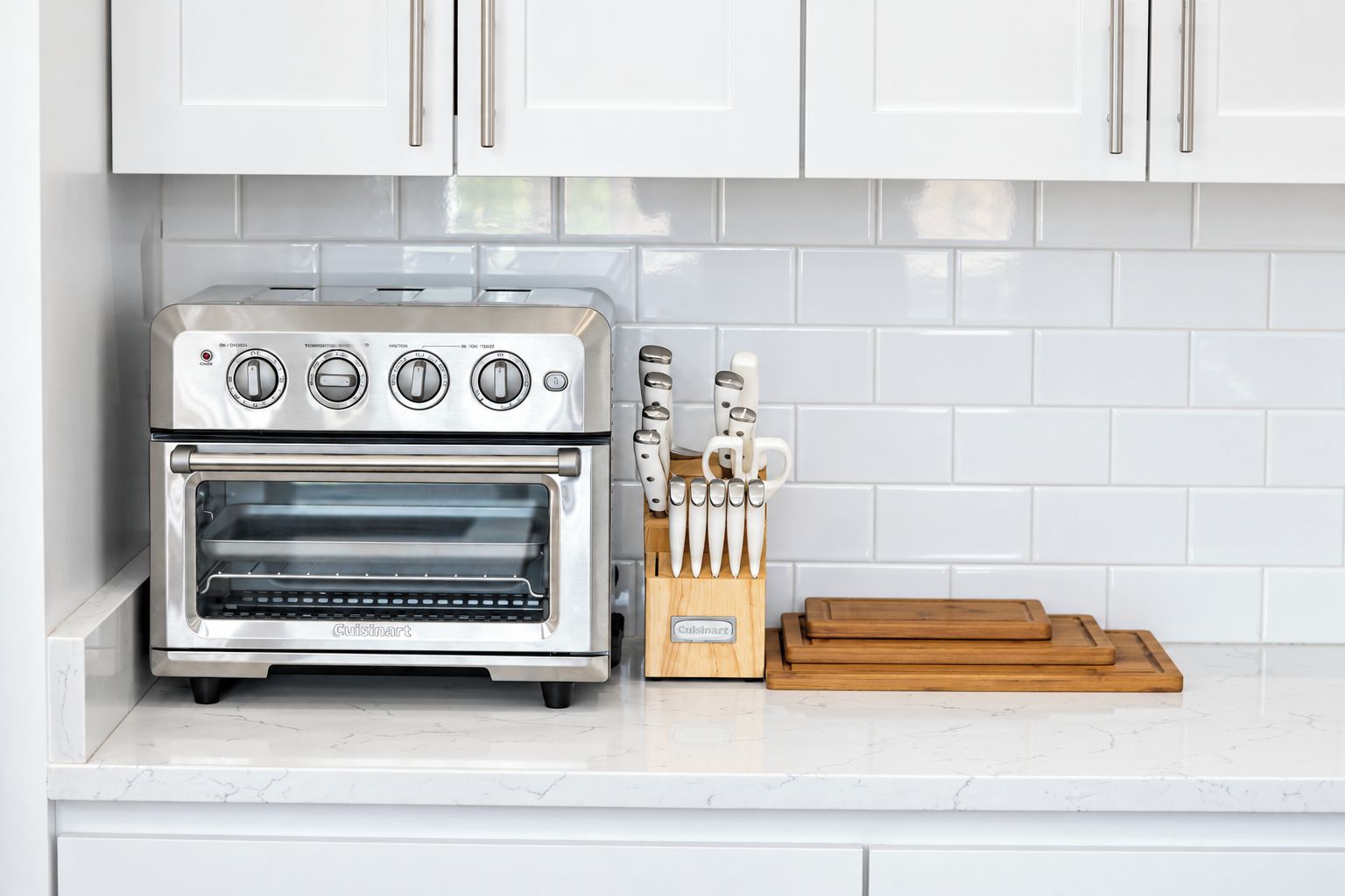 Una cocina con horno empotrado, un bloque de cuchillos y una tabla de cortar.