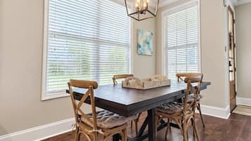 Comedor con una mesa de madera, cuatro sillas y una lámpara colgante.