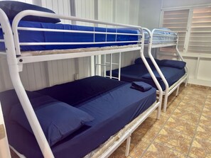 A bunk bed with blue bedding in a room with tiled flooring. - Spacious & Colorful Haven with Pool Tables & Pool (Cabo Rojo)
