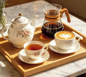 A tray with a teapot, a coffee maker, and a cup of coffee with latte art. - Room-bed & Free Breakfast Edinburgh Dire (Edinburgh)