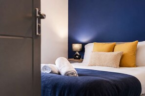 Ein Hotelzimmer mit Bett, Nachttisch und Lampe.