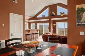 A dining area with a large wooden table, chairs, and a decorative bowl centerpiece. - Cedar Sunset - Big Views, Two Fireplaces, 4BR on Beech Mountain (Beech Mountain)