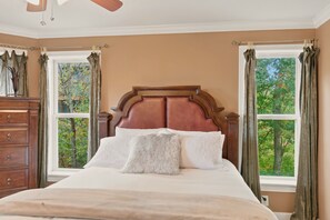 A bedroom with a large bed, wooden headboard, and two windows with curtains. - Cedar Sunset - Big Views, Two Fireplaces, 4BR on Beech Mountain (Beech Mountain)