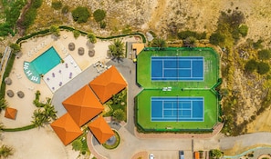 An aerial view of a resort with a swimming pool, tennis courts, and a beach area. - Villa Sail Away | Private Jacuzzi & Courtyard (Noord)