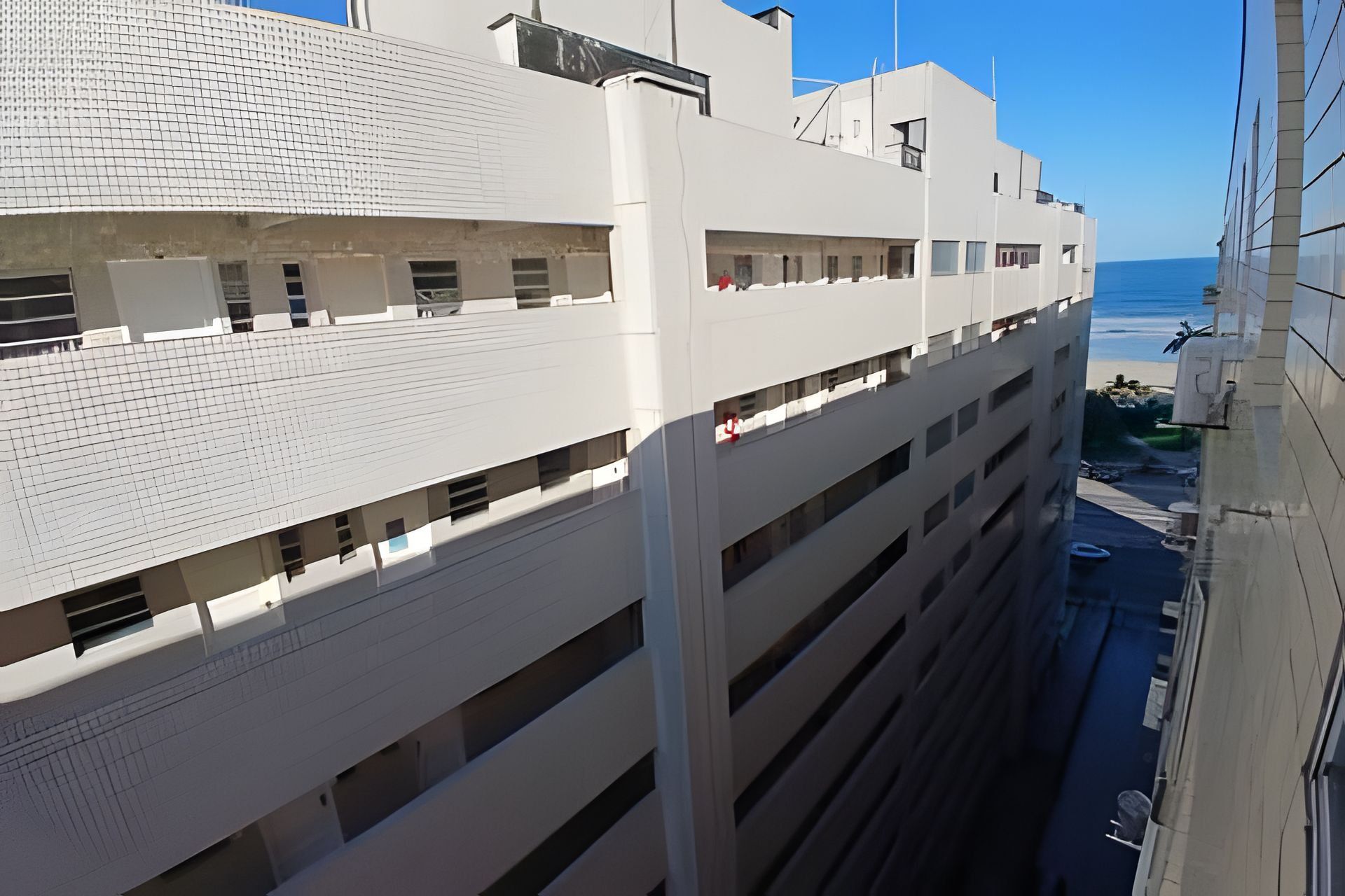 A multi-story building with a modern architectural design, featuring a series of balconies and large windows.
