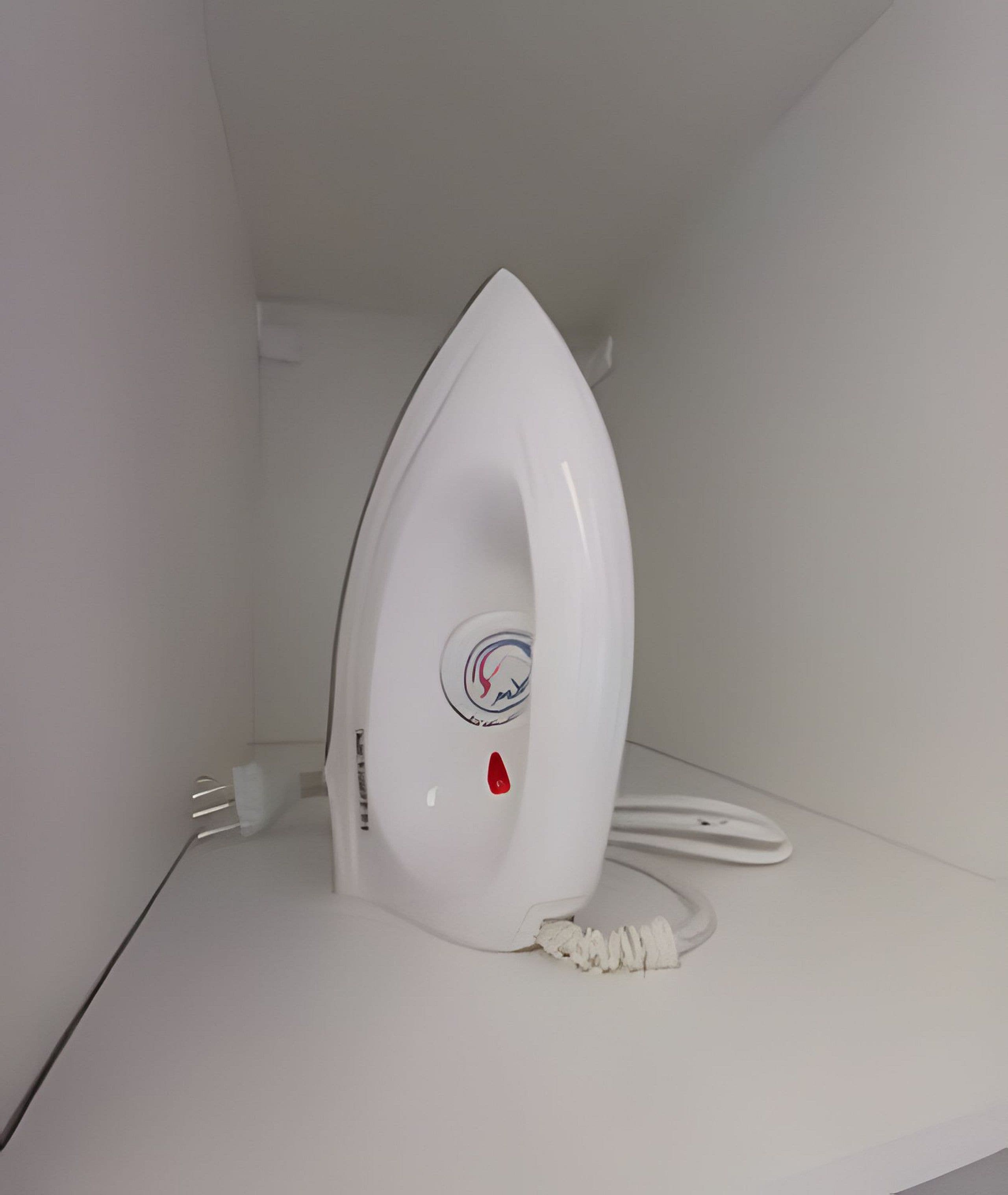 A white iron on a white surface, possibly a shelf or table.