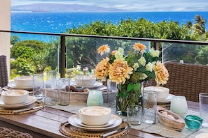 A table set for dining with a view of the ocean, a vase of flowers, and various glassware. - Wailea Beach | 2 Oceanfront Villas, Sleeps 14 | Car Incl. w/ 6+ Nights | ML-4274 by KBM (Wailea)