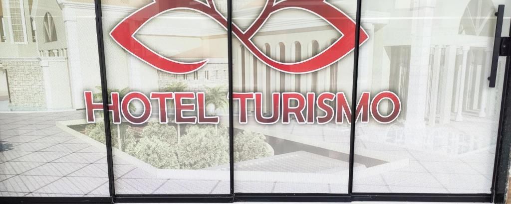 A hotel entrance with a logo and name 'HOTEL TURISMO' prominently displayed.