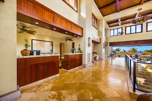 A spacious lobby with a reception desk, a ceiling fan, and a view of the ocean. - Wailea Beach | 2 Oceanfront Villas, Sleeps 14 | Car Incl. w/ 6+ Nights | ML-4280 by KBM (Wailea)