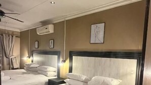 Une chambre d’hôtel avec deux lits, un grand miroir et un ventilateur de plafond.