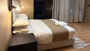 Une chambre à coucher avec un lit, une table de chevet et un luminaire au plafond.