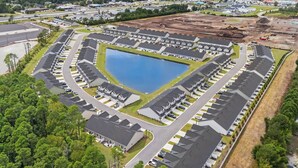 Et stort boligkompleks med en central sø, anlagt i et rillemønster med parkeringspladser.