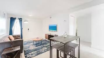 Un salon moderne avec un canapé, une table basse et une table à manger.