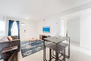 Un salon moderne avec un canapé, une table basse et une table à manger.