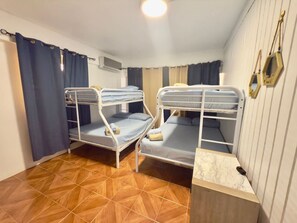 Ein Zimmer mit zwei Etagenbetten, Holzboden und einer Marmorplatte.
