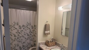 Un baño con inodoro, lavamanos y cortina de ducha.