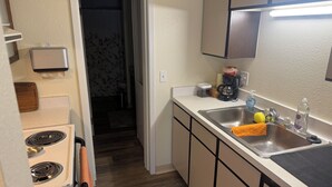 A kitchen with a stove, sink, and cabinets. - Welcome to Mountain Mist Lodge! (Fort Collins)