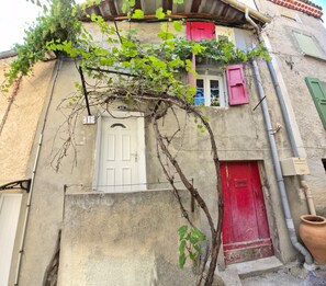 Un edificio con una puerta blanca, una roja y el número 15 en la pared.