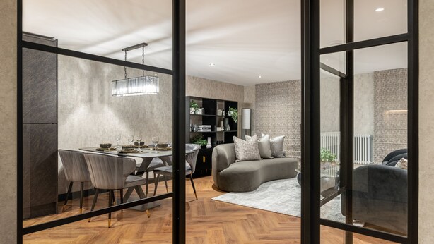 A modern interior with a dining area, a sofa, and a bookshelf.