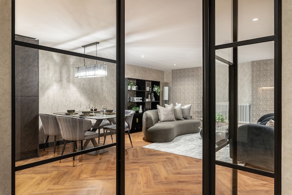 Un interior moderno con una zona de comedor, un sofá y una estantería.